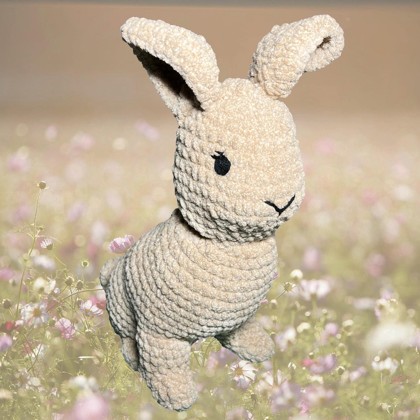 Crocheted bunny toy in a field of flowers