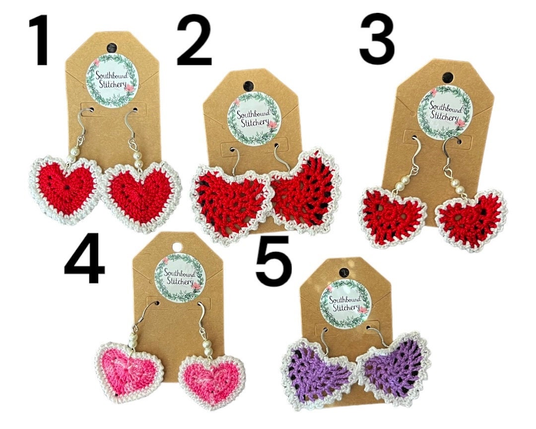 Heart-shaped earrings on display with tags indicating brand or seller.