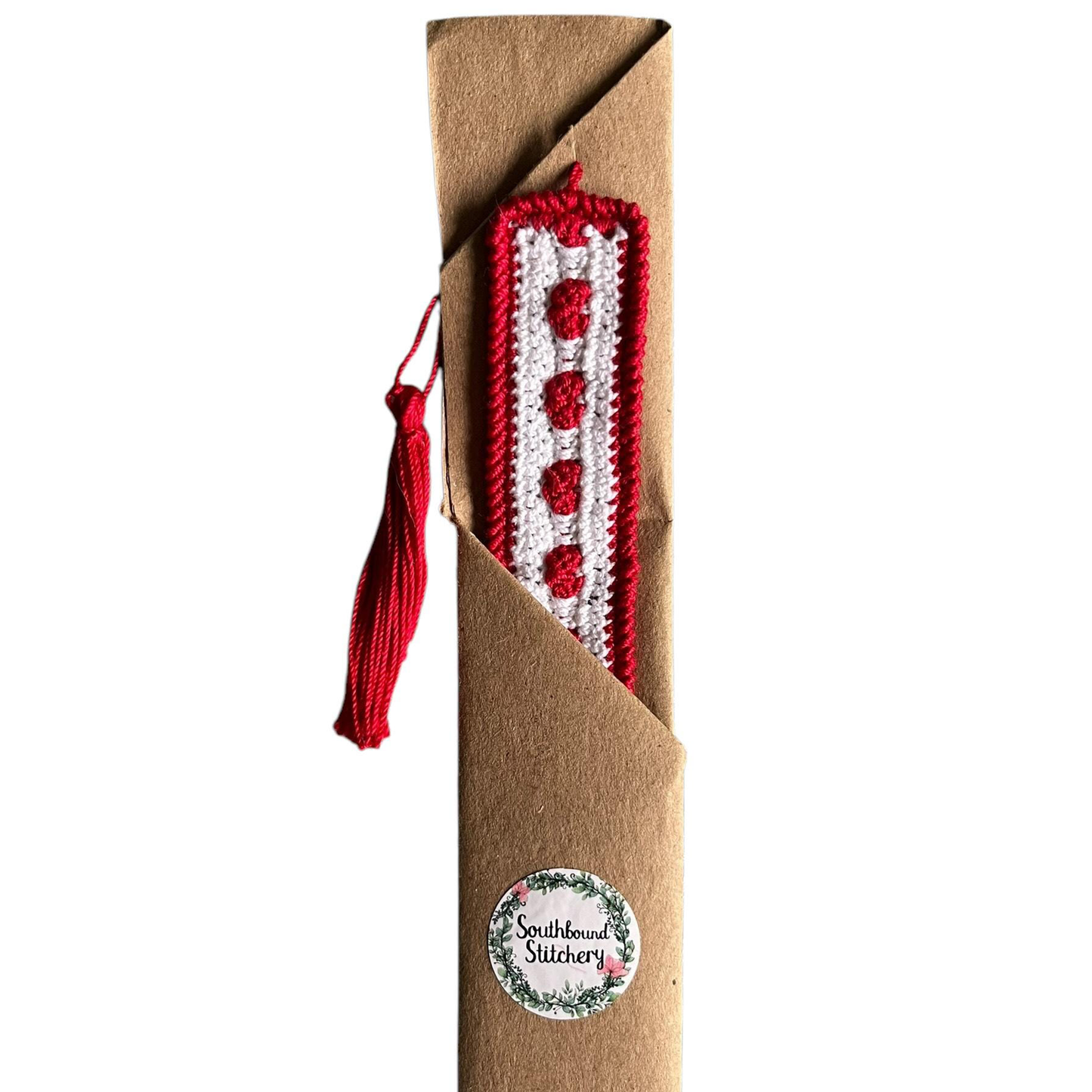 Crocheted bookmark with red and white heart pattern on a brown background, featuring 'Southbound Stitchery' branding.