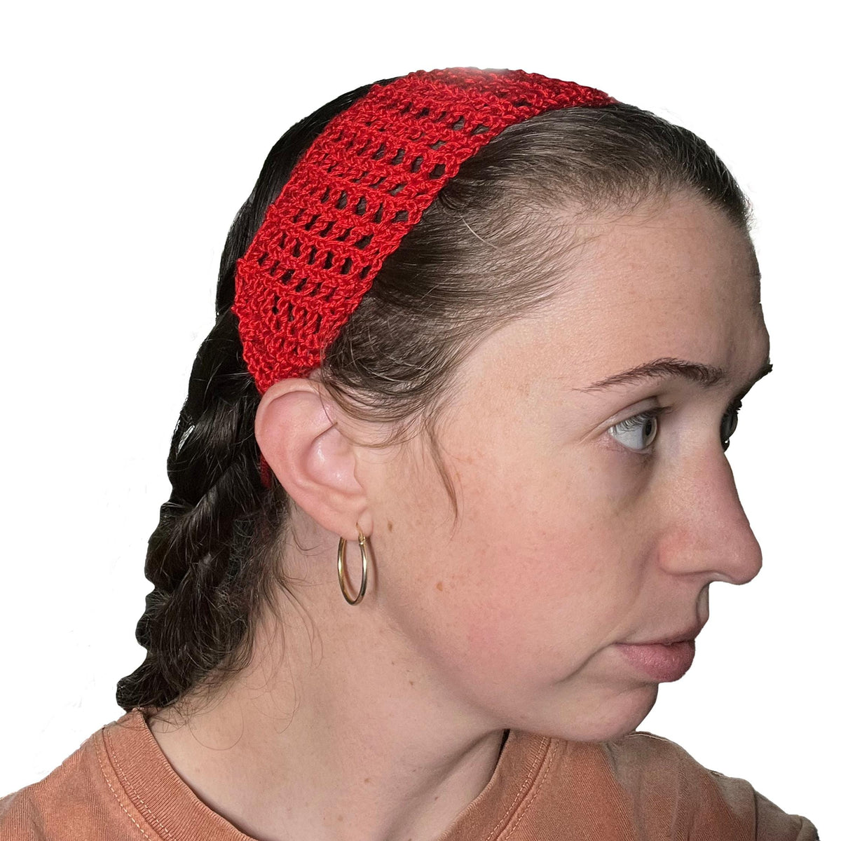 Person wearing a red crocheted headband on a white background