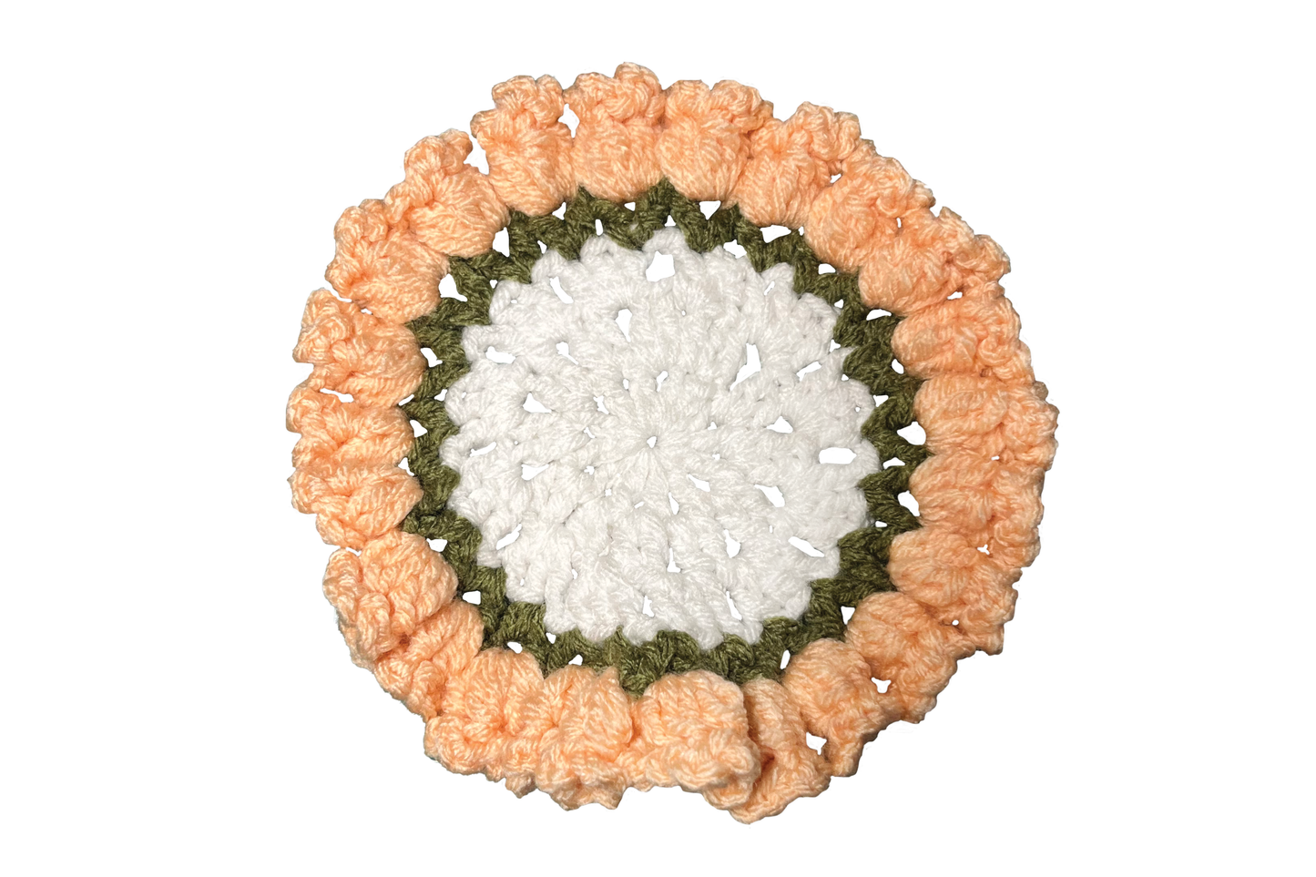 Round crocheted coaster with peach and green border on a white background