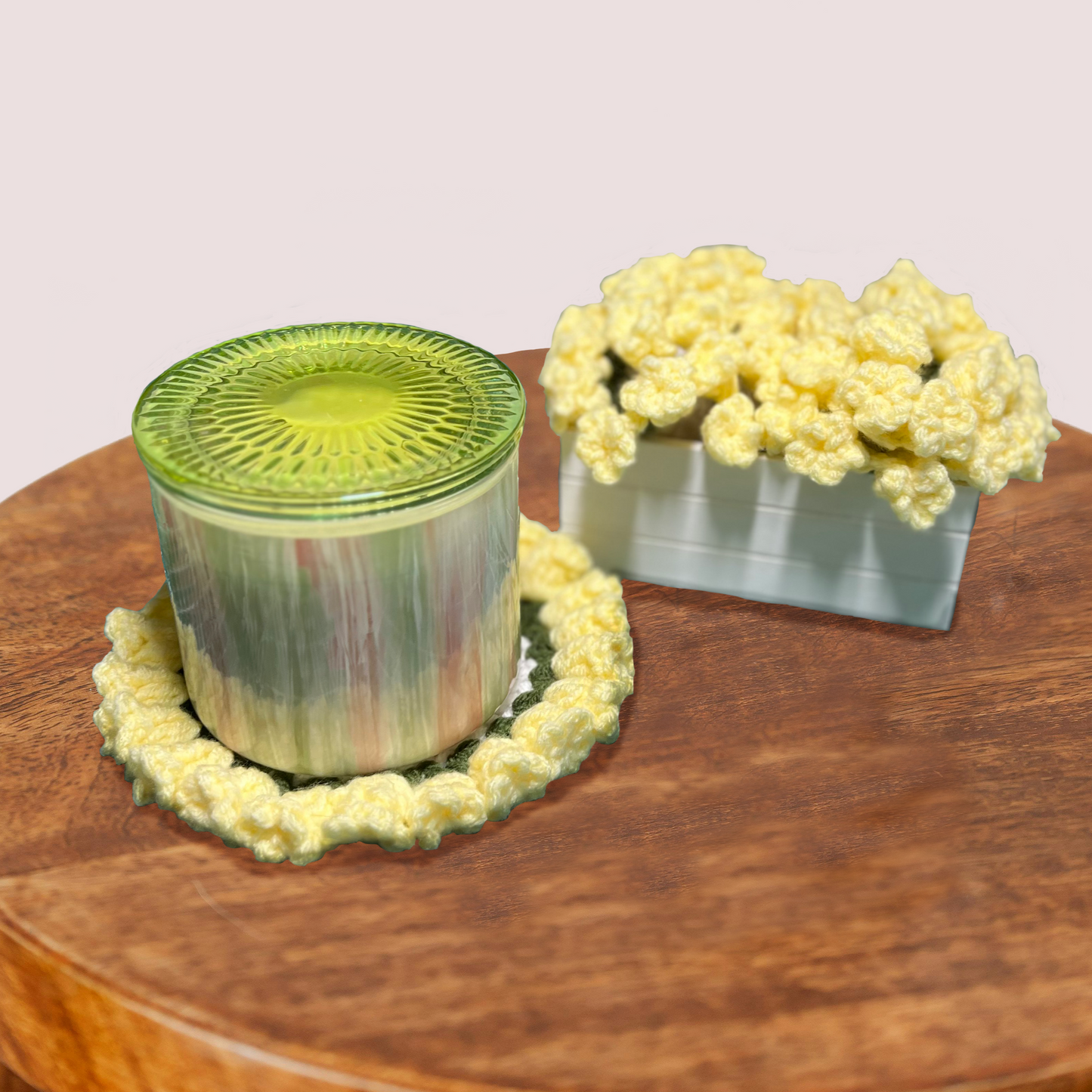 Decorative crocheted coaster with a candle on a wooden surface