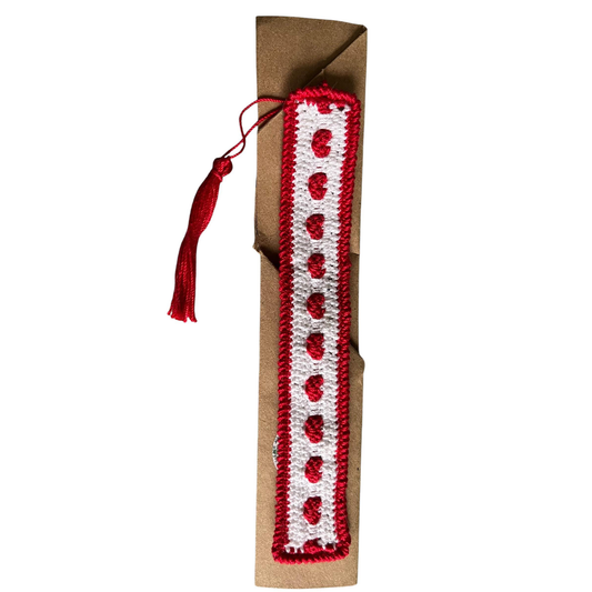 Crocheted bookmark with red and white heart pattern on a white background